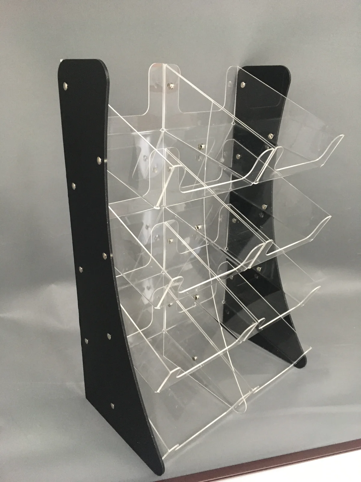 Stand for leaflets joined from black acrylic and clearj — six kieszeni