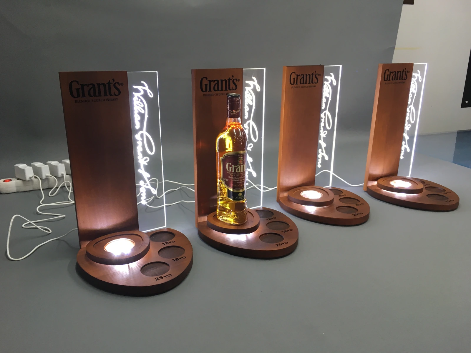 Grant's — Whisky bottle display with LED backlight, wooden base from sheet metal and acrylic with a neon, presenting the bottle