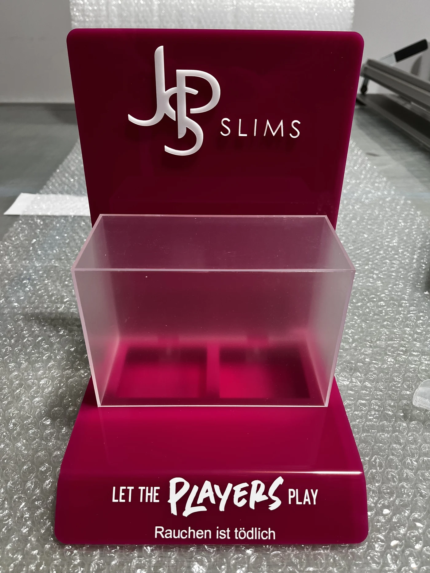 JPS Slims — countertop display from red acrylic, logo 3D white, komunikat ostrzegawczy ‚Rauchen ist tödlich' — eksport DE