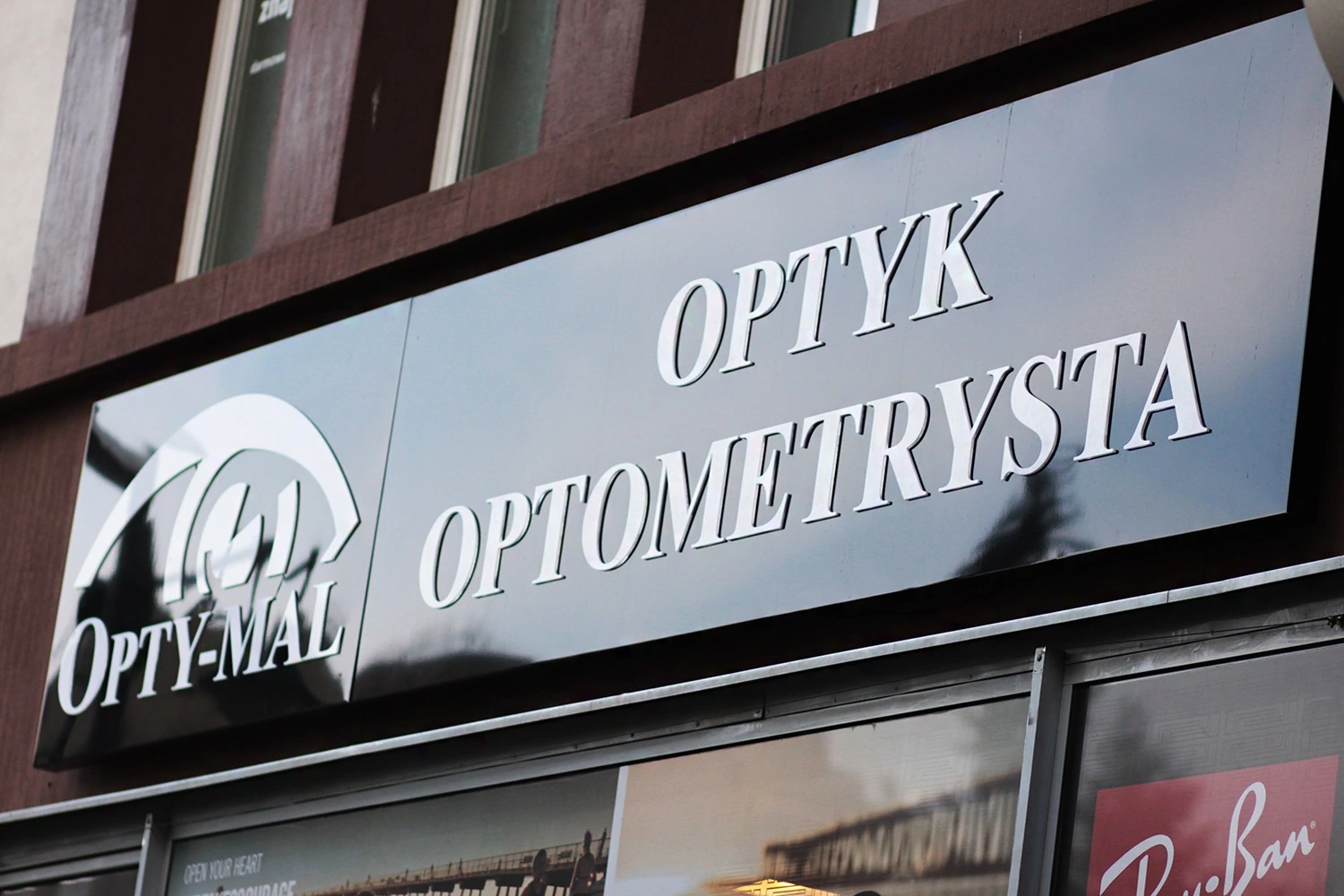 OPTI-MAL — Advertising lightbox with logo and OPTYK OPTOMETRYSTA inscription, made from acrylic/composite material, illuminated