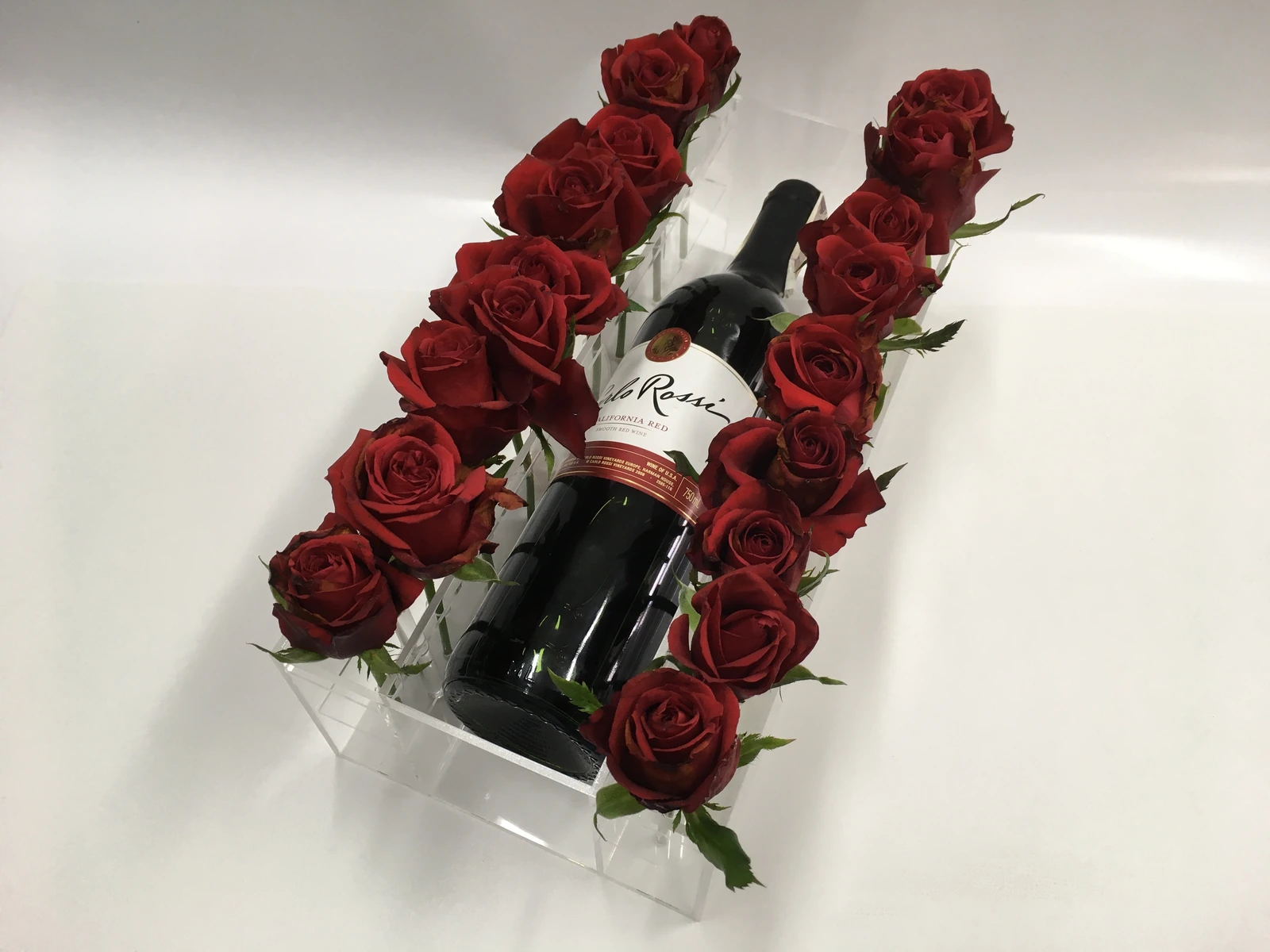 Penfolds — Wine bottle display with red roses, made from transparent acrylic, constituting an elegant product display